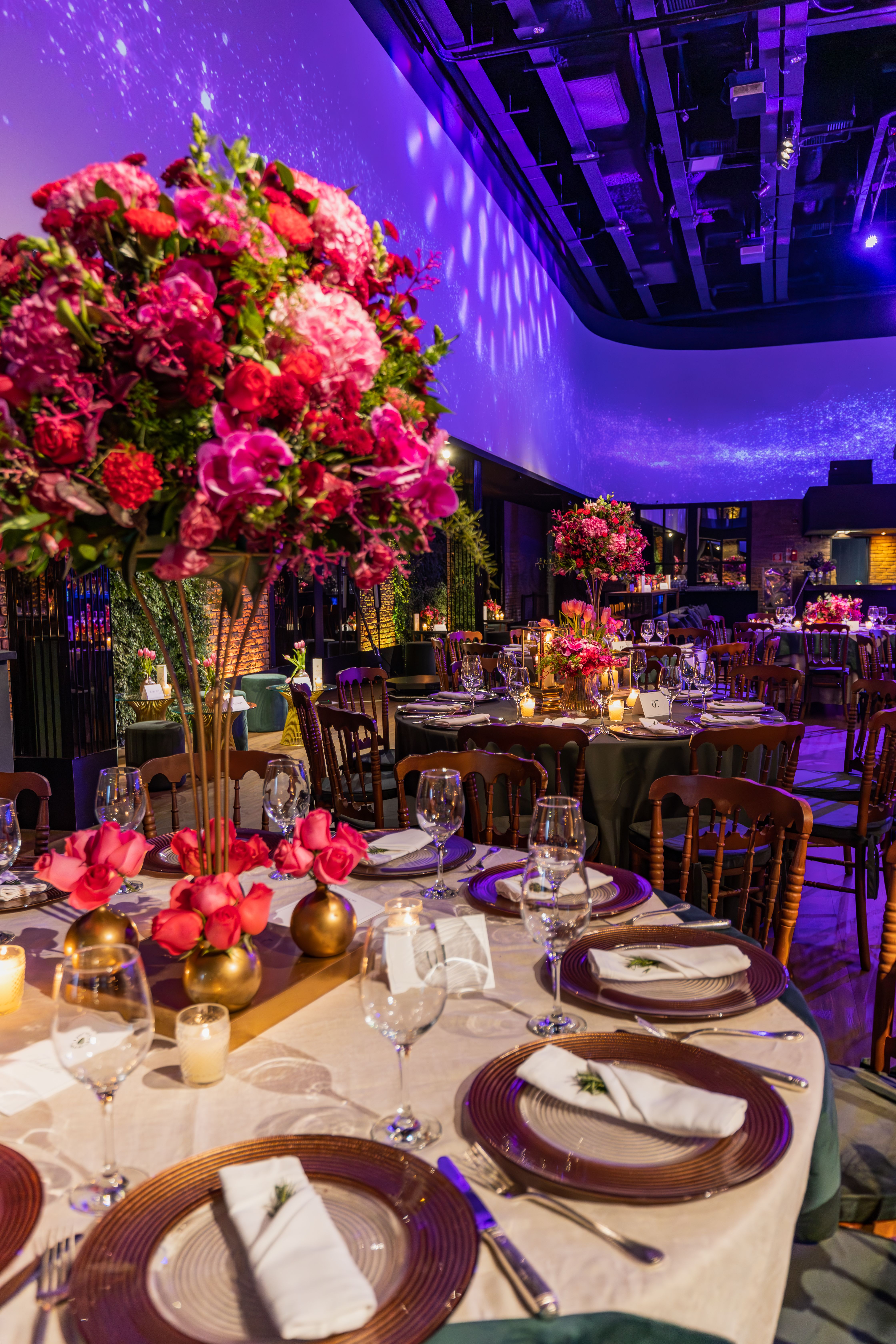 Luxury ballroom event setup with vibrant floral arrangements and elegant tablescapes